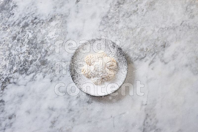 Kahk in black pottery plate on grey marble background