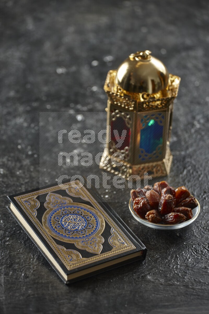 A golden lantern with different drinks, dates, nuts, prayer beads and quran on textured black background