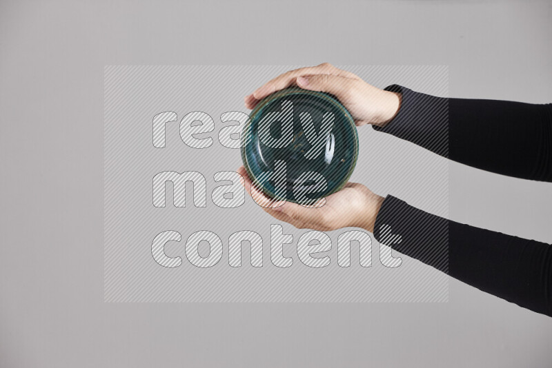 A woman in black abaya holding different pottery essentials in different positions