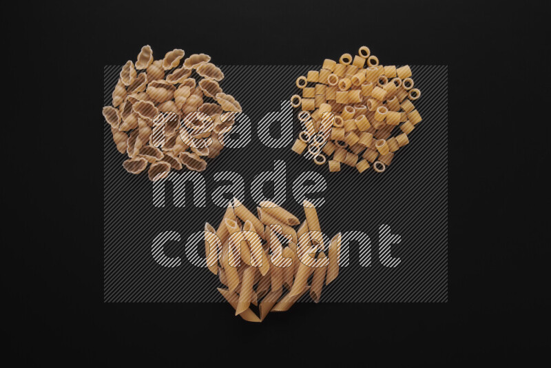 Different pasta types in bunches on black background