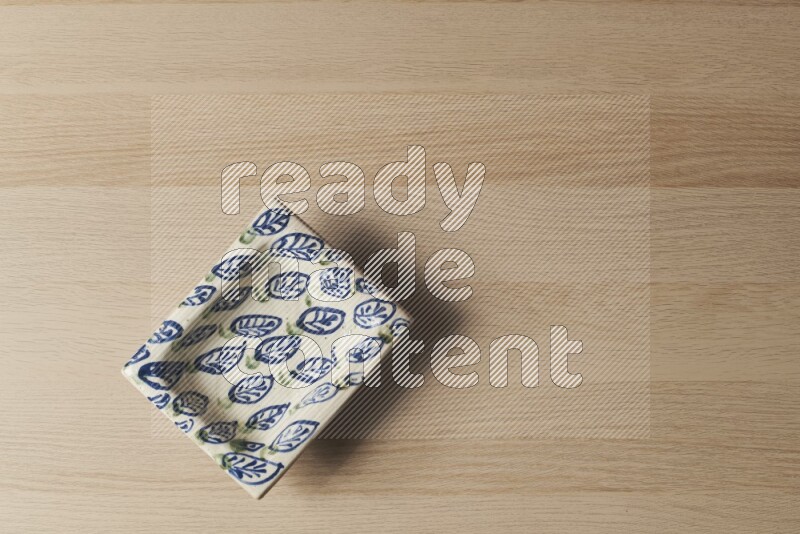 صحن فخاري مزخرف على خلفية خشبية فاتحة