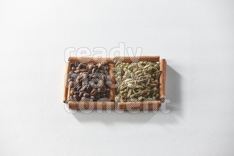 2 squares of cinnamon sticks full of cardamom and coffee beans on white flooring