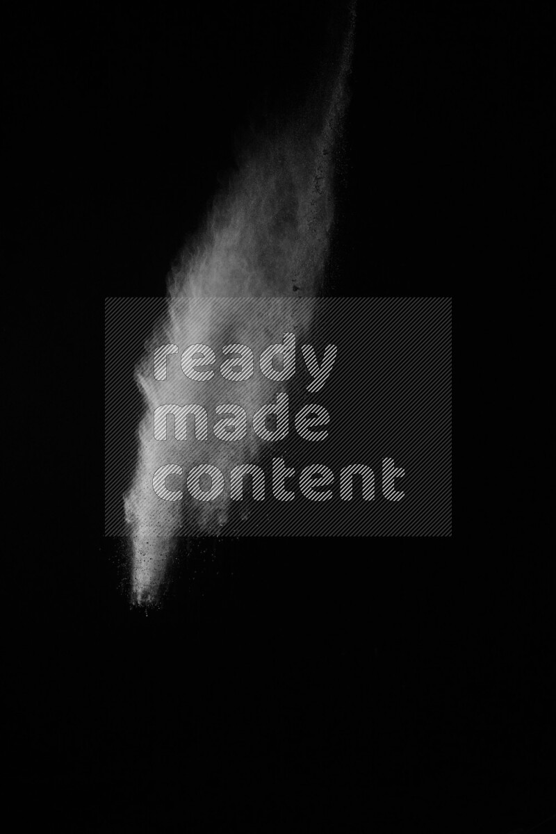 A side view of white powder explosion on black background