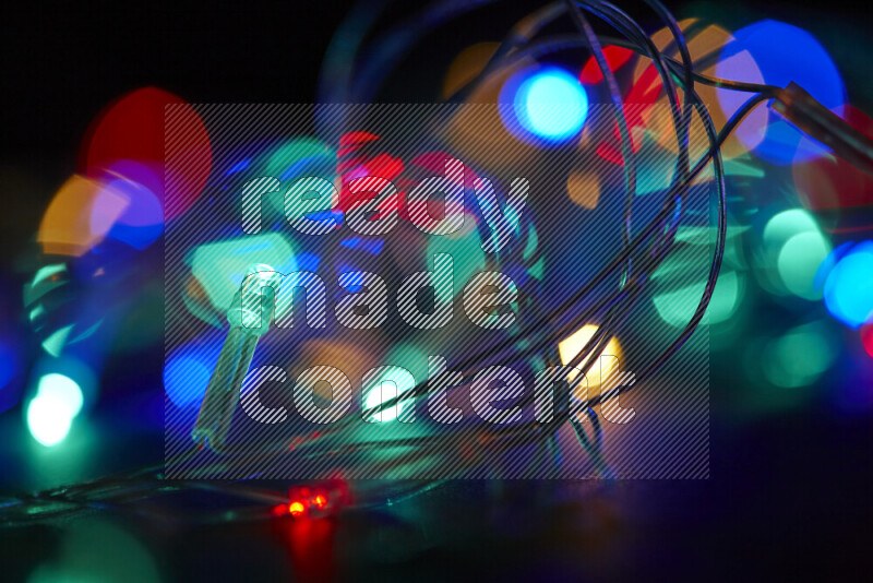 Light bulbs glowing against backdrop of multicolord bokeh