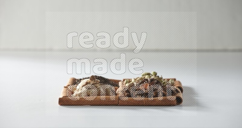 4 squares of cinnamon sticks full of tea, cardamom, star anise and ginger on white flooring