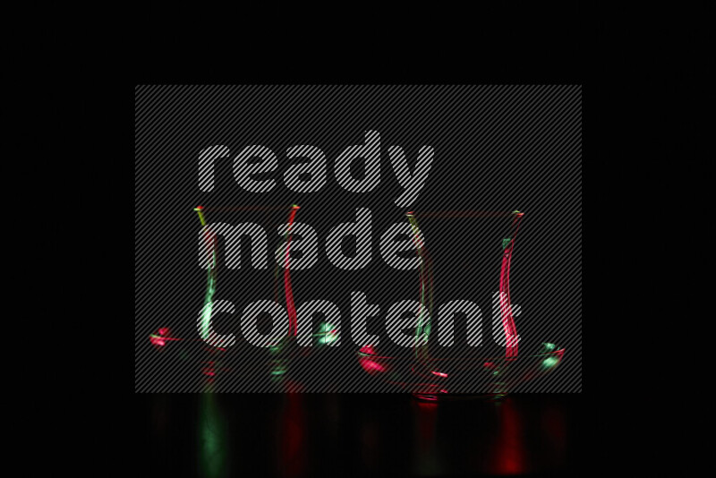 Glassware with rim light in red and green against black background