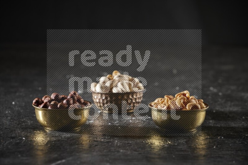 Nuts in a metal bowl in a dark setup
