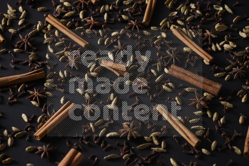 Cinnamon Sticks, Star anise, Cardamom and cloves on a black background