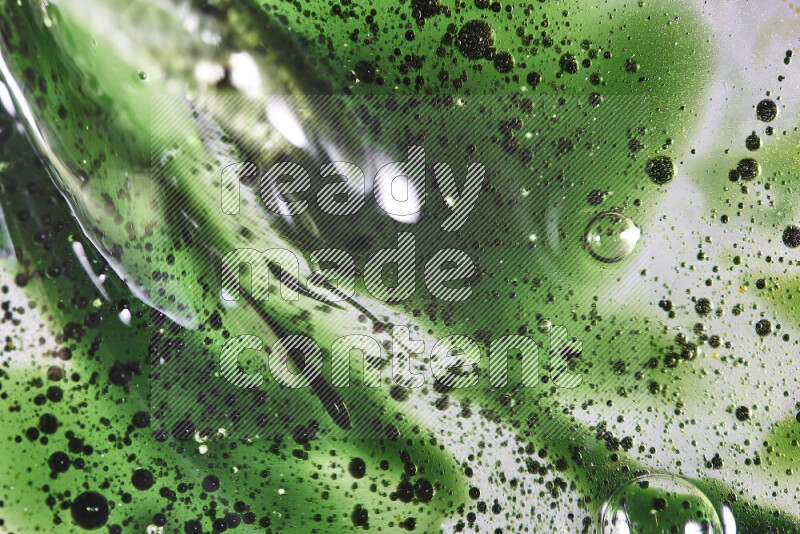 Close-ups of abstract green watercolor drops on oil Surface on white background