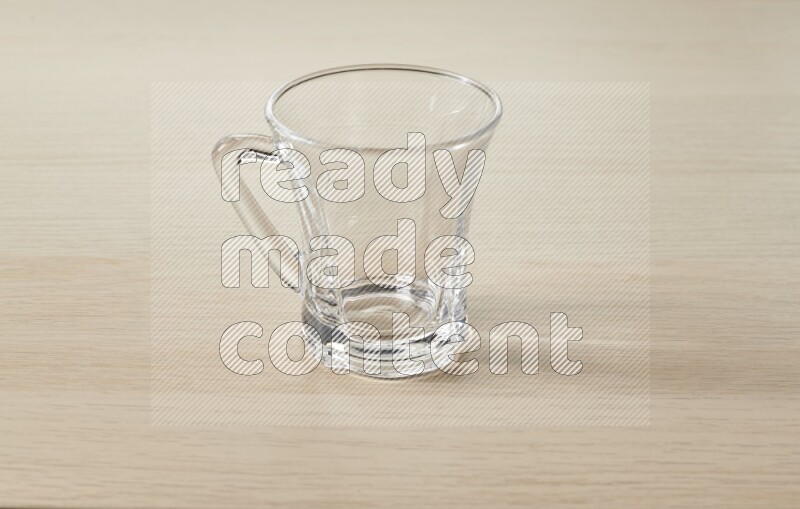An empty glass cup on light wooden background