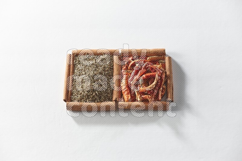 2 squares of cinnamon sticks full of dried red chilis and cumin on white flooring