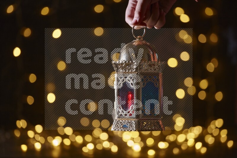 A traditional ramadan lantern surrounded by glowing fairy lights in a dark setup