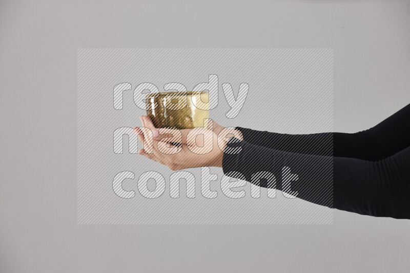 A woman in black abaya holding different pottery essentials in different positions