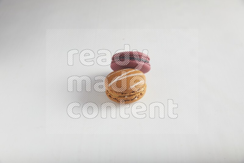 45º Shot of of two assorted Brown Irish Cream, and Red Cherry macarons on white background