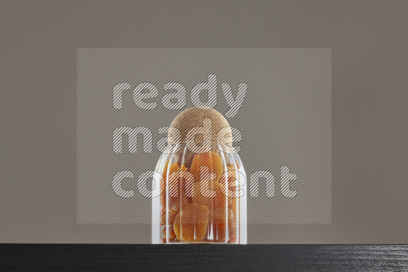 Dried apricots in a glass jar on black background