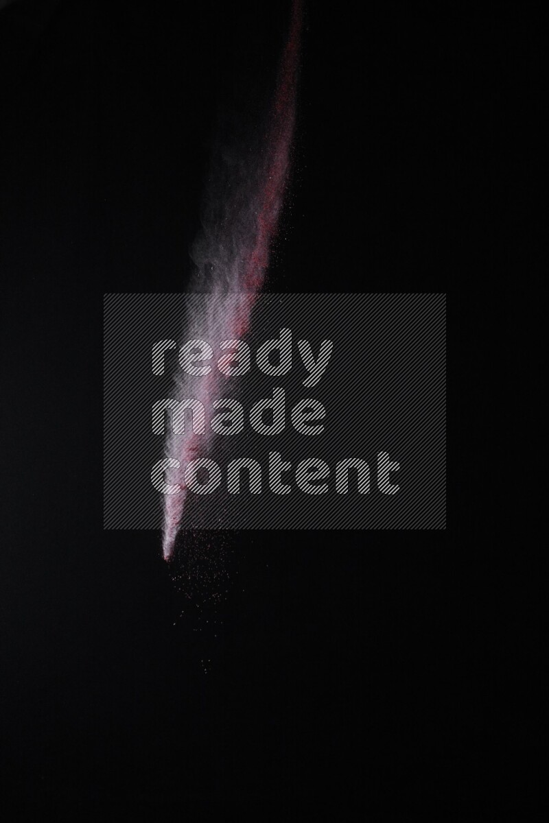 A side view of red powder explosion on black background