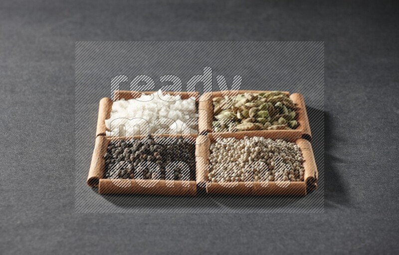 4 squares of cinnamon sticks full of black pepper, white pepper, cardamom and white salt on black flooring