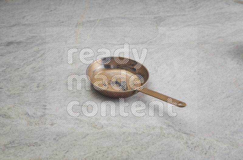A small copper pan on grey marble background