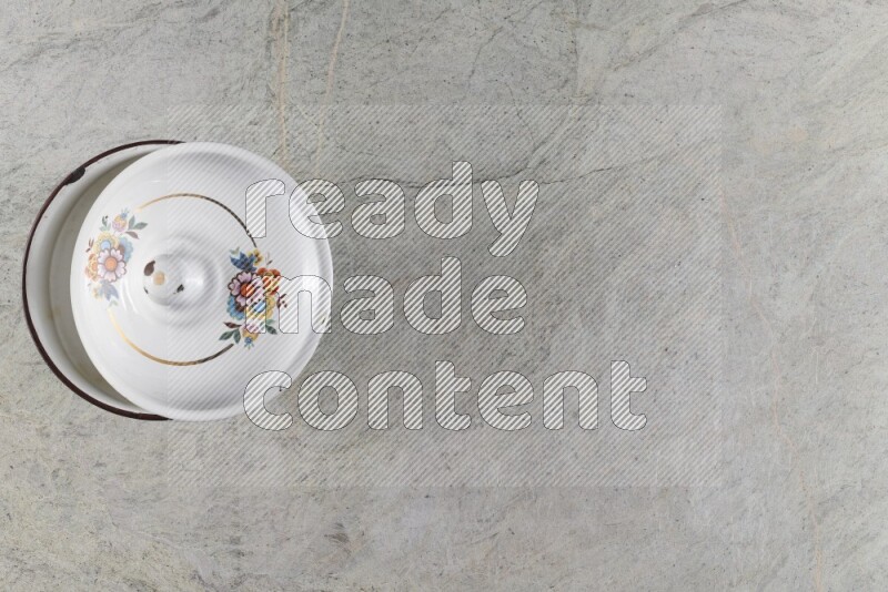 A vintage metal pot on grey marble background