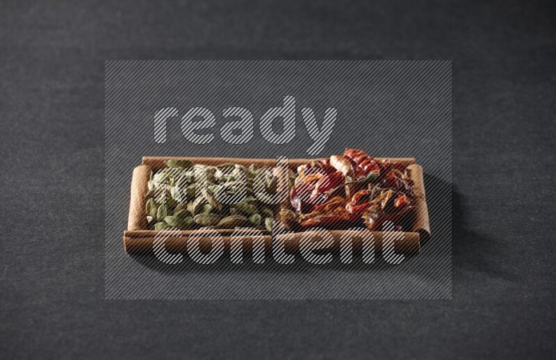 2 squares of cinnamon sticks full of chilis and cardamom on black flooring