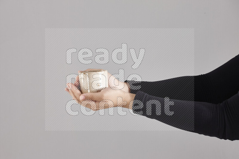 A woman in black abaya holding different pottery essentials in different positions