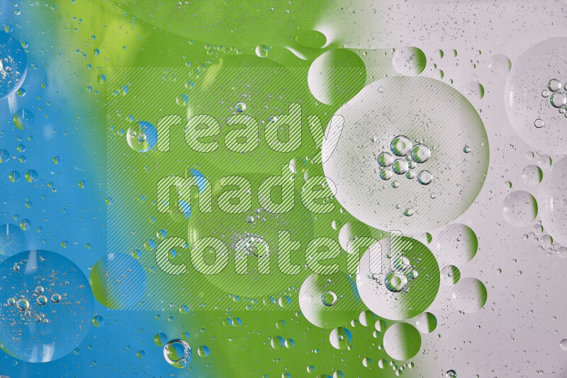 Close-ups of abstract oil bubbles on water surface in shades of white, green and blue