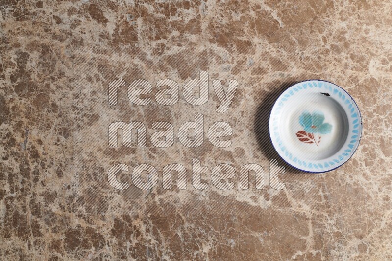 A vintage metal plate on beige marble background