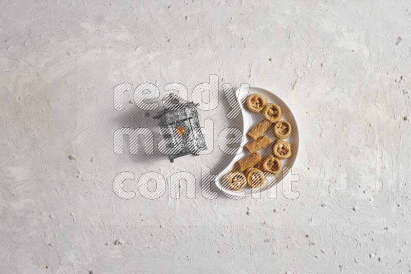 حلويات شرقية في صحن فخاري مع فانوس معدني