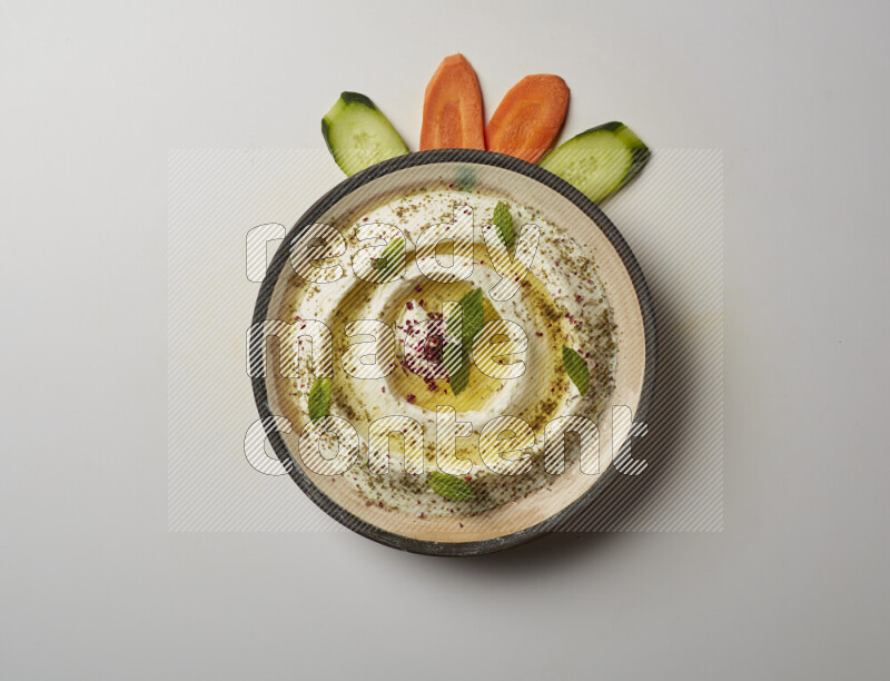 Lebnah garnished with zaater, mint & sumak in a pottery plate on a white background