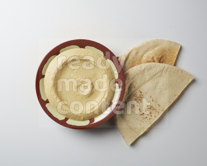 Plain hummus in a traditional plate on a white background