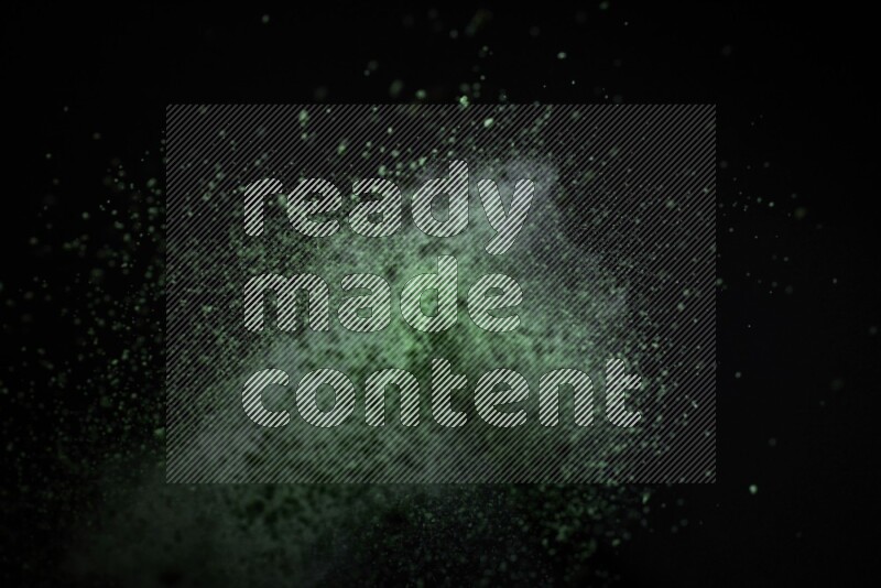 Green powder explosion on black background