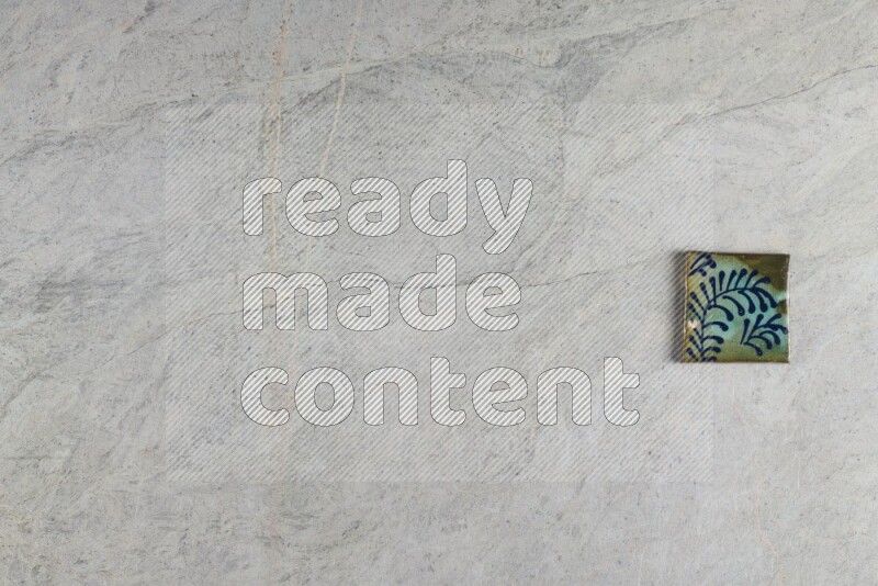 A decorative pottery coaster on grey marble background