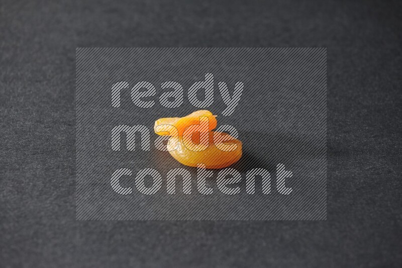 Two dried apricots on a black background in different angles