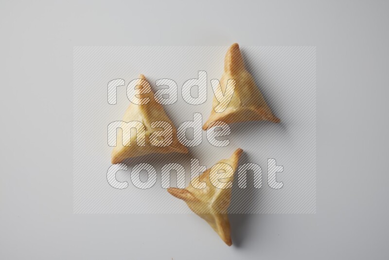 Three fried sambosa from a top angle on a white background