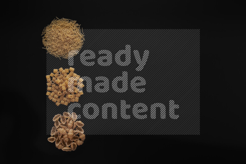 Different pasta types in 3 bunches on black background
