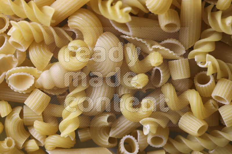 Different pasta types on light blue background