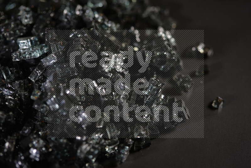 Transparent black fragments of glass scattered on a black background