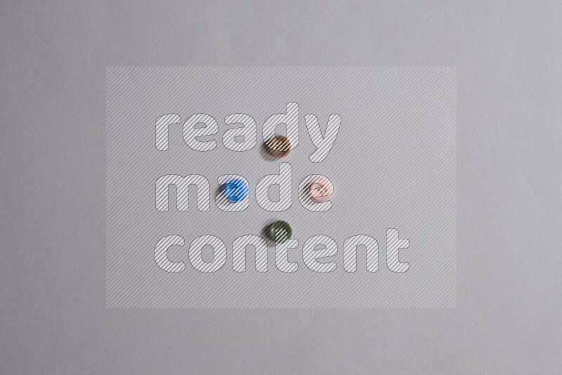 أزرار متعددة اﻷلوان موضوعة علي خلفية رمادية