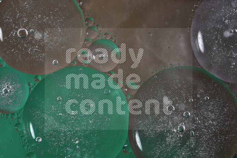 لقطات مقربة لفقاعات من الزيت على سطح الماء باللون الأخضر والبني