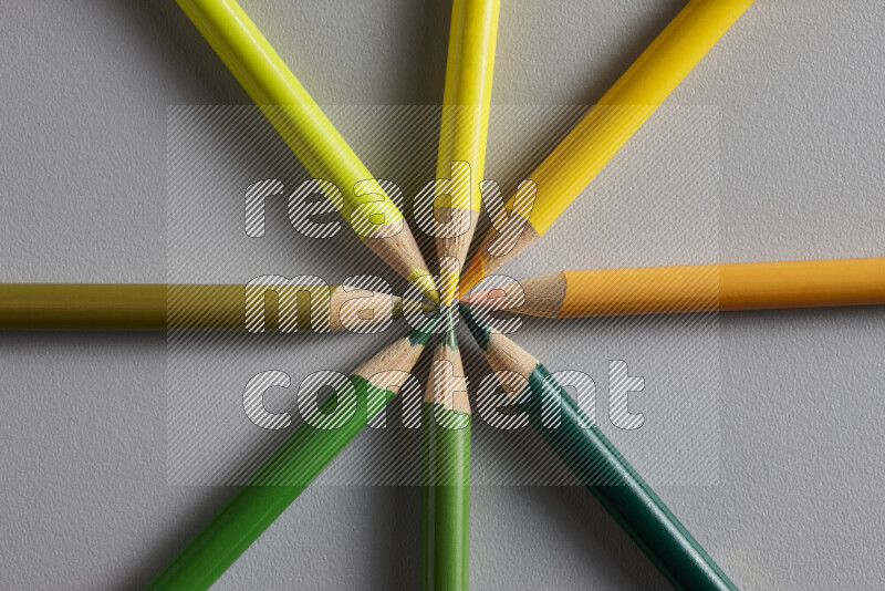 An arrangement of colored pencils in different colors on grey background