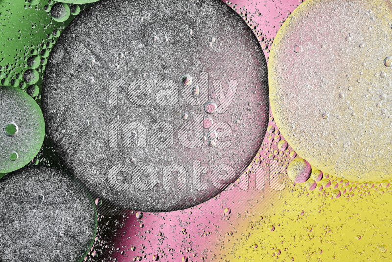 لقطات مقربة لفقاعات من الزيت على سطح الماء باللون الأصفر والأخضر والوردي