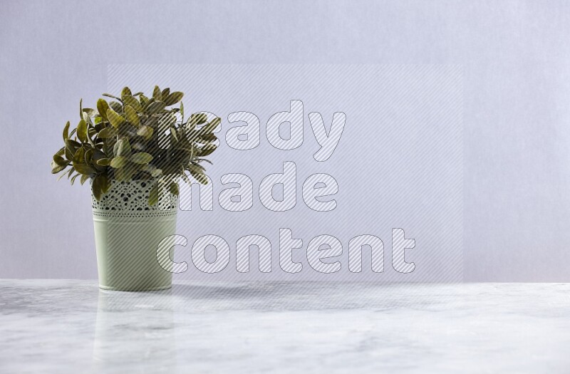 Artificial plant in green decorative pot on grey marble background