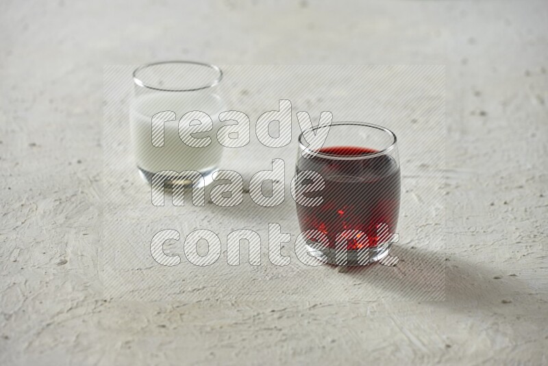 Cold drinks in a glass cup such as water, tamarind, qamar eldin, sobia, milk and hibiscus on textured white background