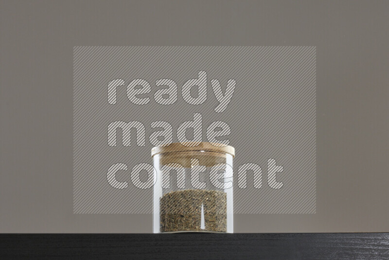 Cumin in a glass jar on black background