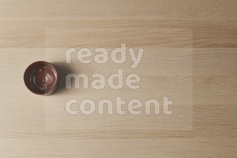 وعاء فخاري بني على خلفية خشبية فاتحة