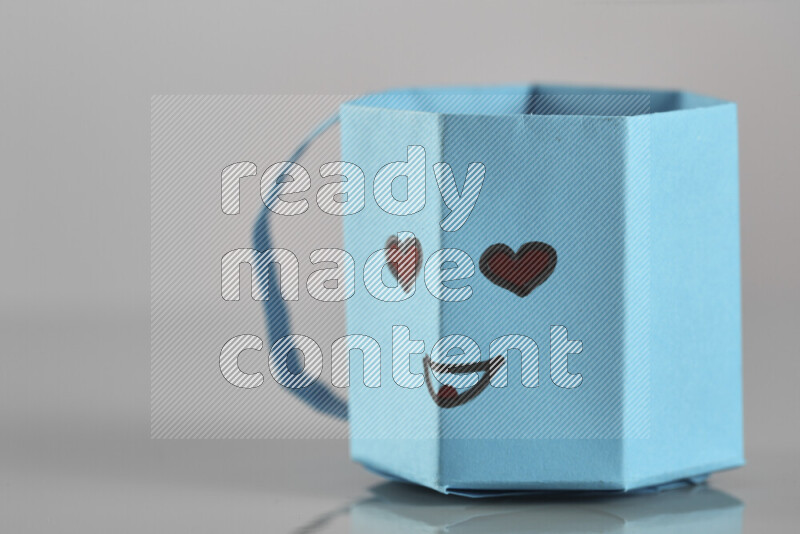 Origami cup on grey background