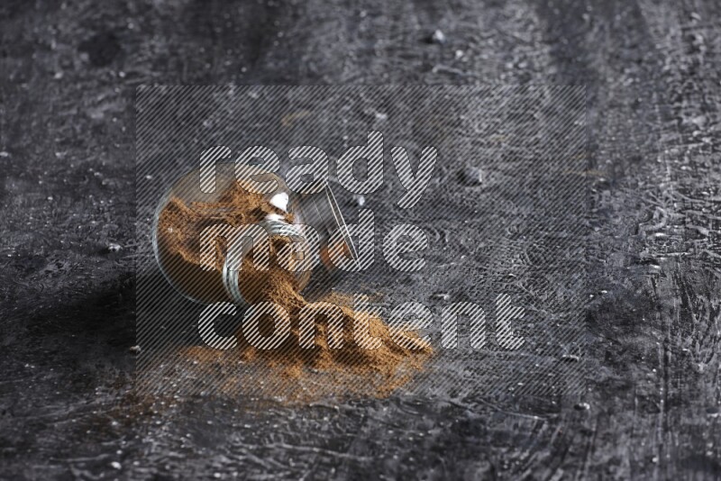 قرفة في وعاء زجاجي مقلوب علي خلفية سوداء