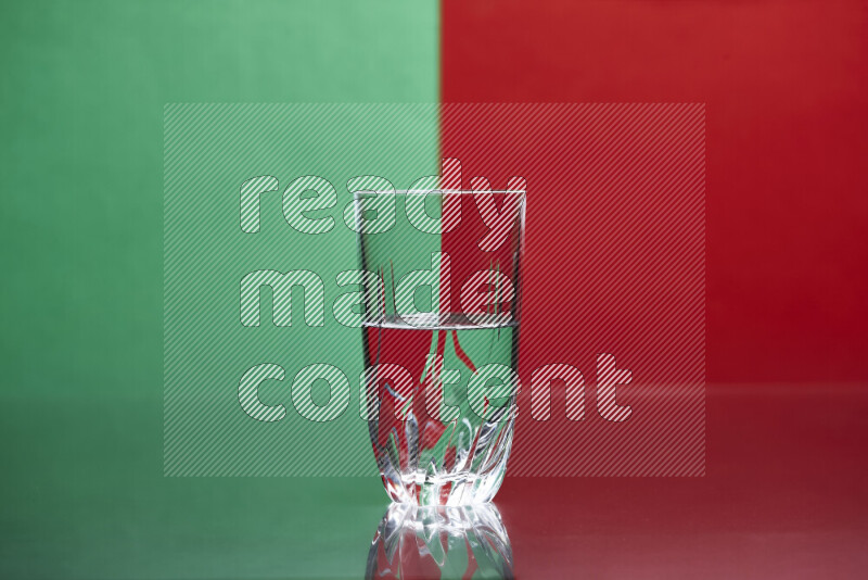 The image features a clear glassware filled with water, set against green and red background