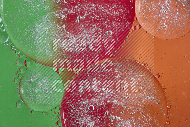 لقطات مقربة لفقاعات من الزيت على سطح الماء باللون البرتقالي والأخضر والأحمر