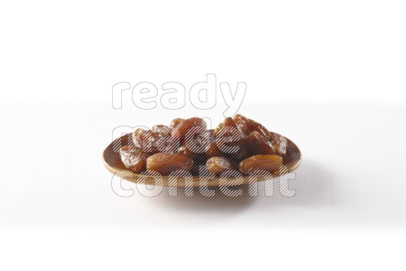 Dates in a wooden plate on white background